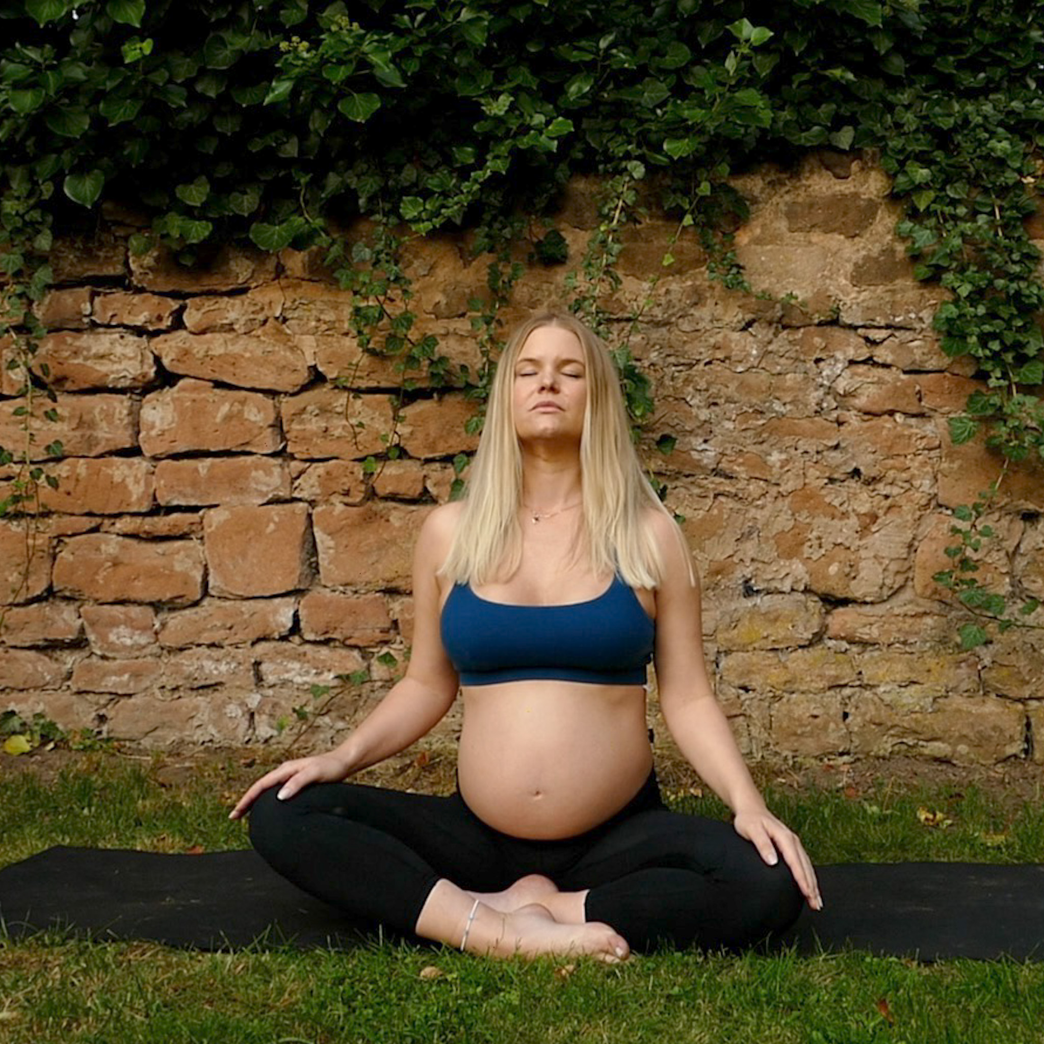 blonde schwangere frau im schneidersitz beim meditieren